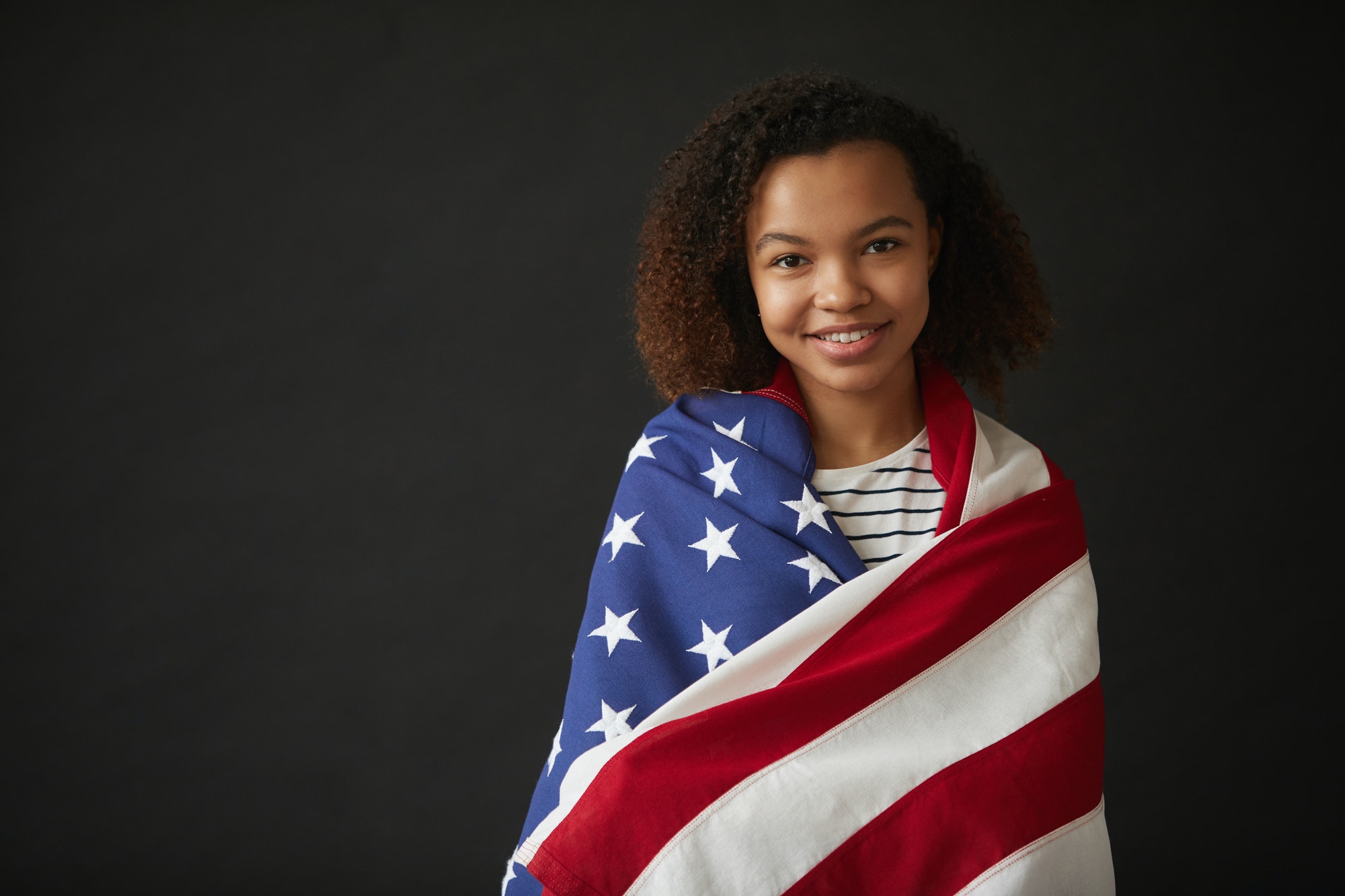 Young African Woman Holding American flag on Black