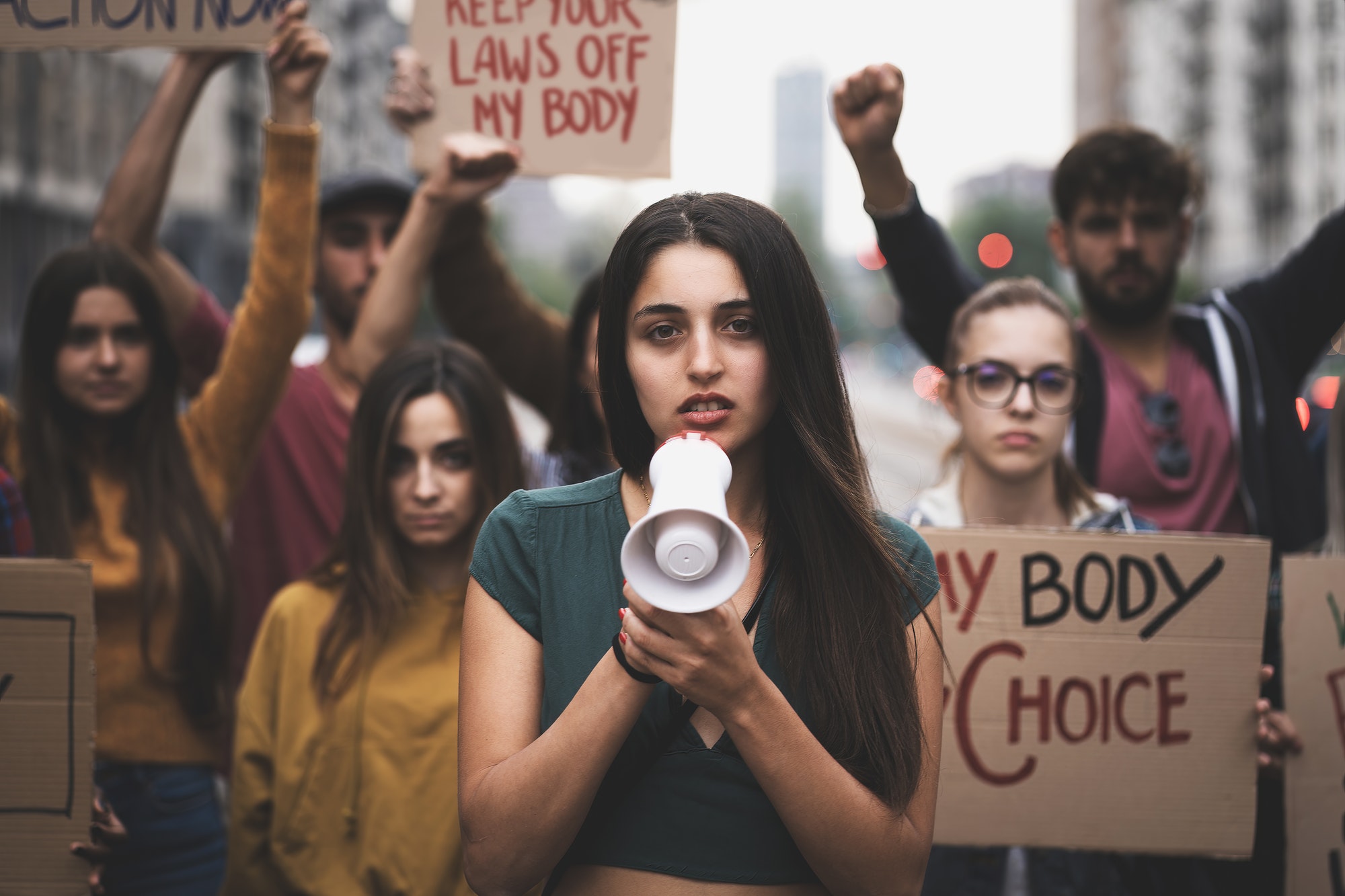 group of young people march in protest to affirm the right to abortion