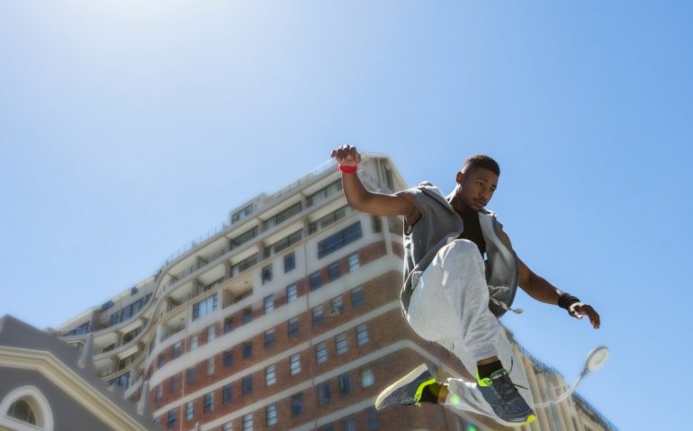 Athletic man doing parkour in the city on a sunny day